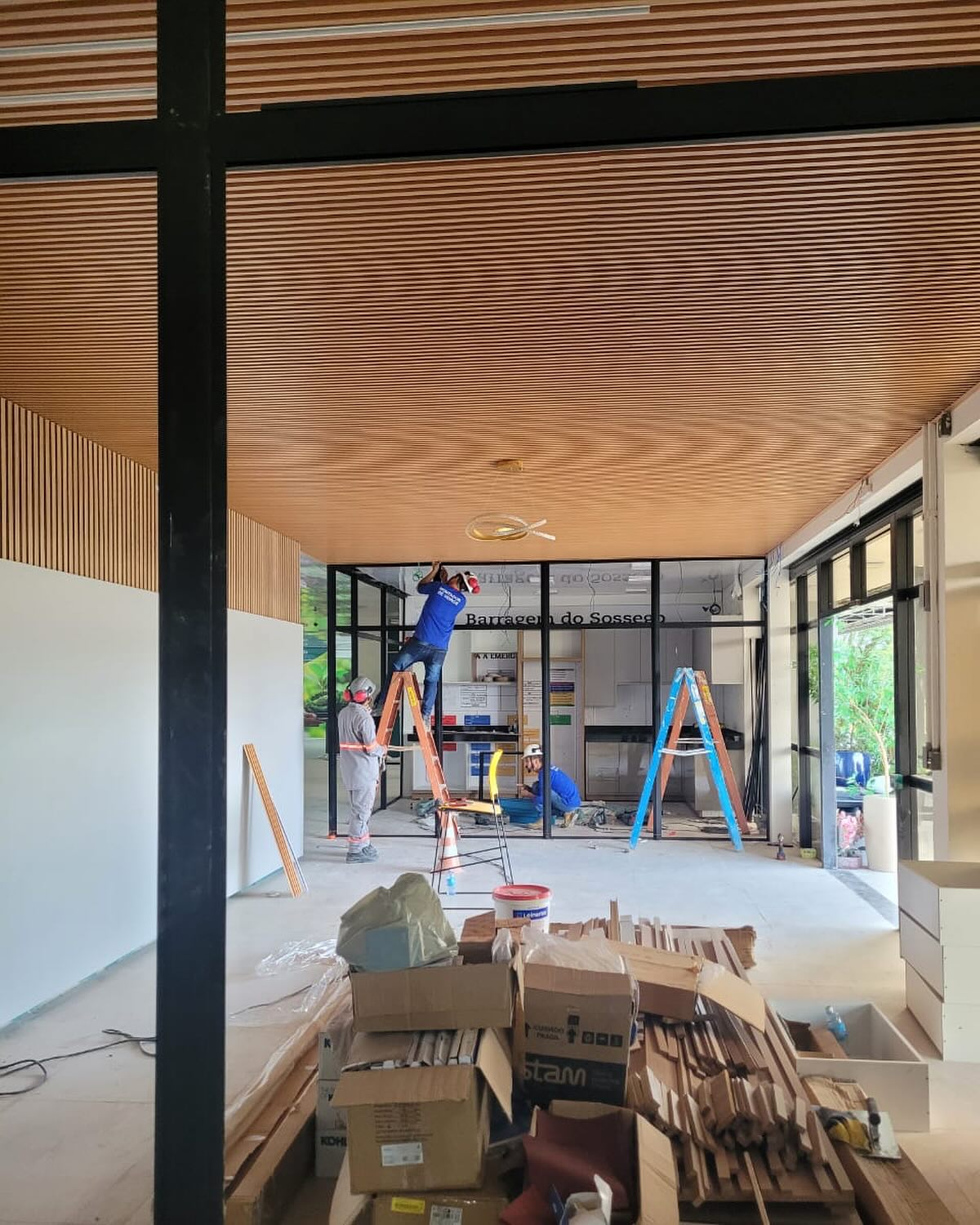 Ambiente comercial amplo com painel ripado amadeirado instalado no teto