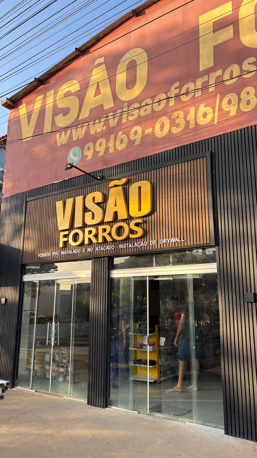 Vista próxima da fachada e entrada da loja Visão Forros